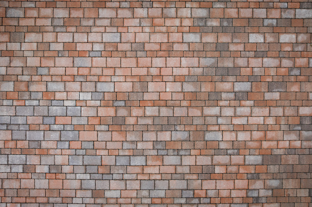 Rote und graue Backsteinwand mit verschiedenfarbigen rechteckigen Steinen